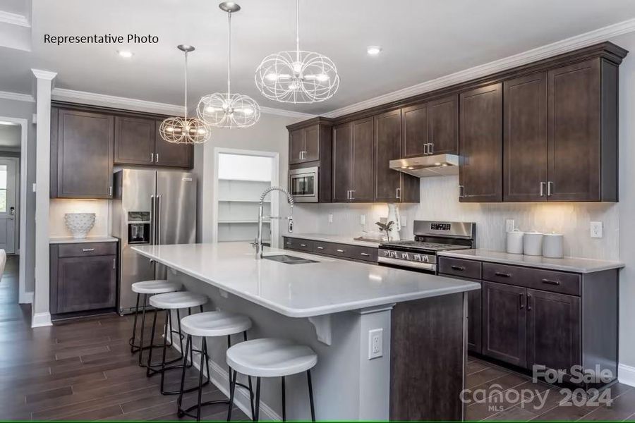 Modern kitchen with large island, substantial storage, and stainless steel appliances