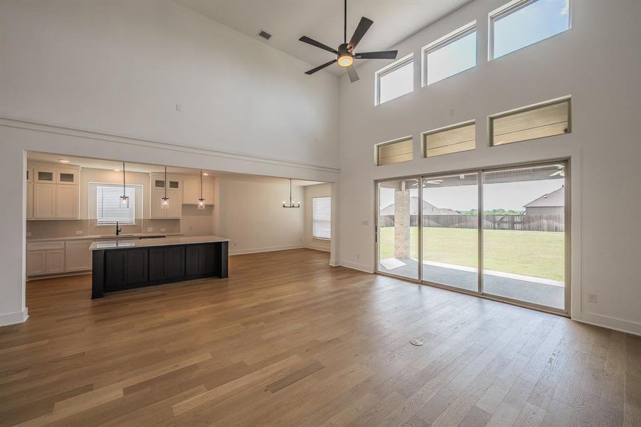 Open concept living area featuring hardwood flooring, a vaulted ceiling, and a ceiling fan