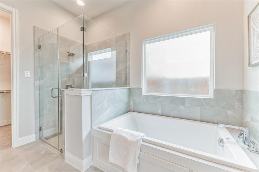 Bathroom with separate shower and tub and tile patterned floors