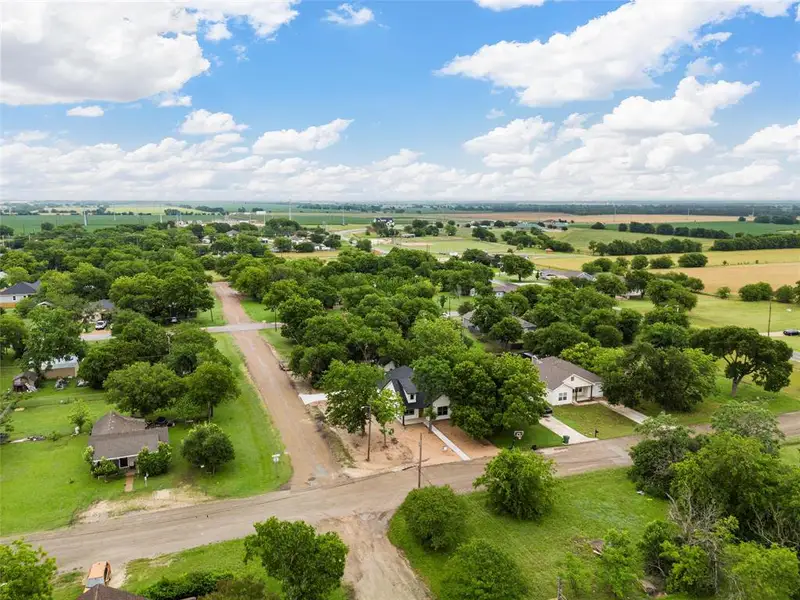 Aerial view of sparsely populated area with a tree filled landscape