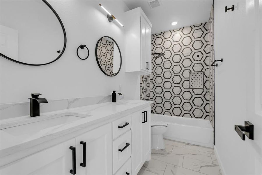 Bathroom with dual vanity, toilet, and tile patterned flooring