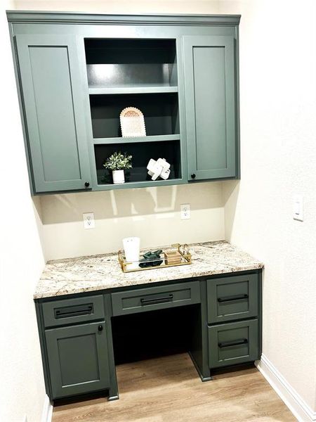 Bar with built in study area, baseboards, and light wood-type flooring Bar with built in study area, baseboards, and light wood-type flooring