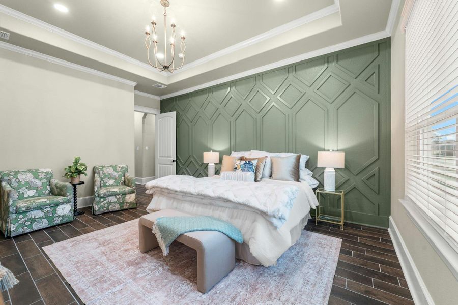 Accent wall with geometric paneling, tray ceiling, wood-finish flooring, recessed lighting, and a chandelier