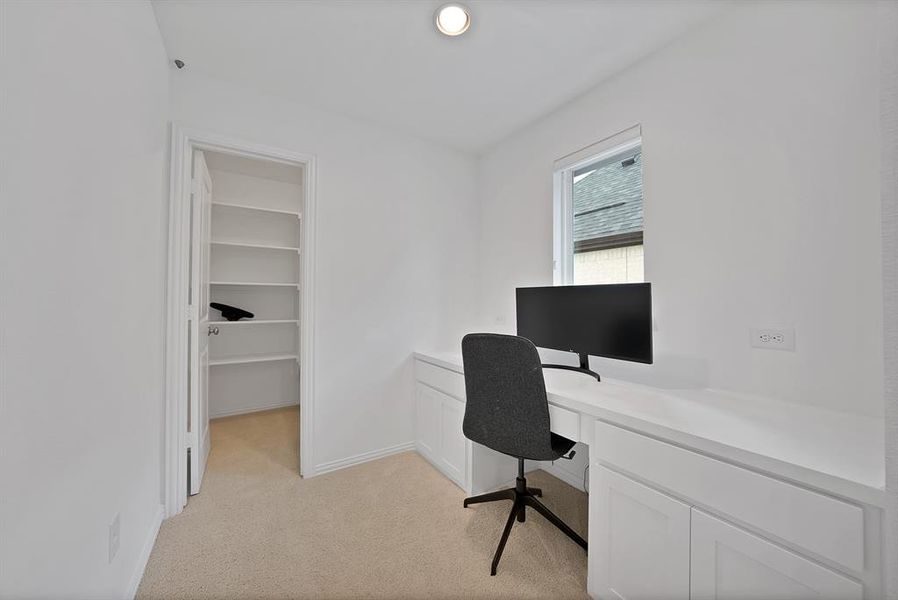 Dedicated workspace featuring a built-in desk, under-cabinet storage, and recessed lighting