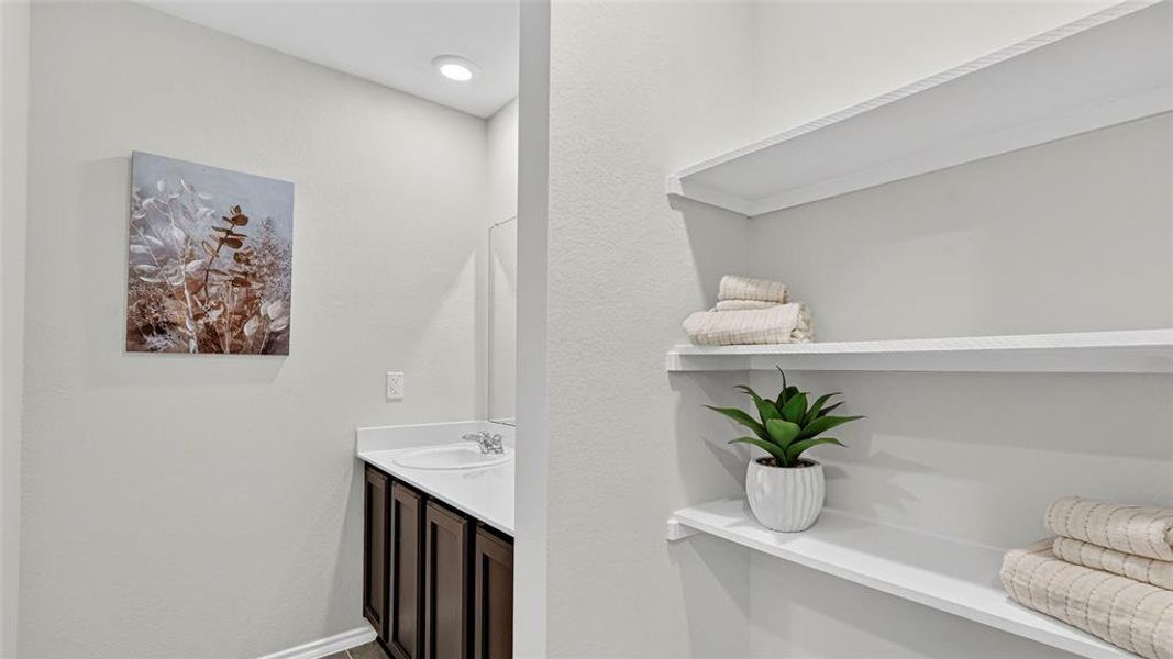 Bathroom vanity with dark wood-finish cabinetry, a white countertop, and an undermount sink Bathroom vanity with dark wood-finish cabinetry, a white countertop, and an undermount sink