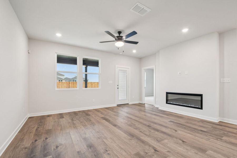 A room with a wood floor and a ceiling fan.