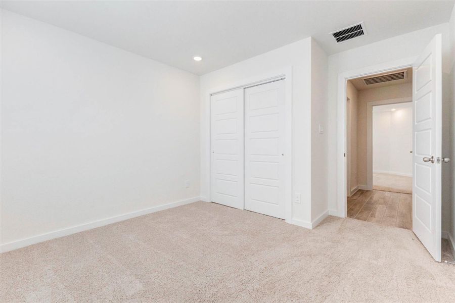 This cozy secondary bedroom features fresh neutral tones, plush carpeting, recessed lighting, and a spacious double-door closet. The layout offers quiet comfort, ideal for guests, kids, or a private workspace. Natural light and clean finishes enhance the room's welcoming feel. This cozy secondary bedroom features fresh neutral tones, plush carpeting, recessed lighting, and a spacious double-door closet. The layout offers quiet comfort, ideal for guests, kids, or a private workspace. Natural light and clean finishes enhance the room's welcoming feel.