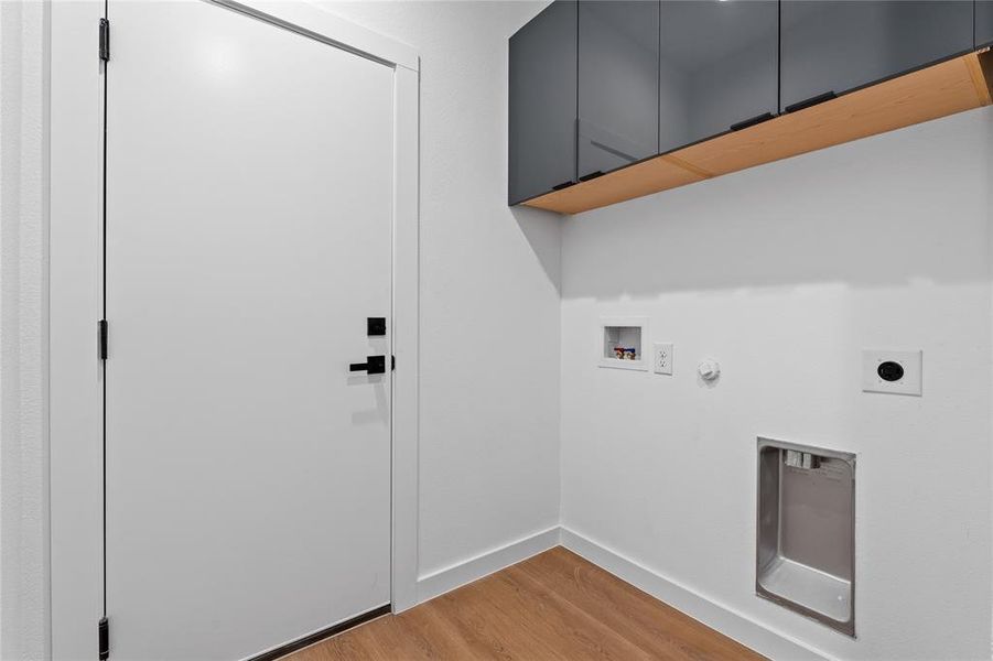 Laundry area with gas dryer hookup, light wood-type flooring, hookup for a washing machine, hookup for an electric dryer, and cabinet space Laundry area with gas dryer hookup, light wood-type flooring, hookup for a washing machine, hookup for an electric dryer, and cabinet space