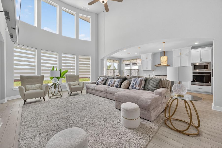 Towering ceilings and panoramic windows create an airy ambiance in this open-concept family space. The kitchen and living room flow effortlessly for entertaining or everyday relaxation.