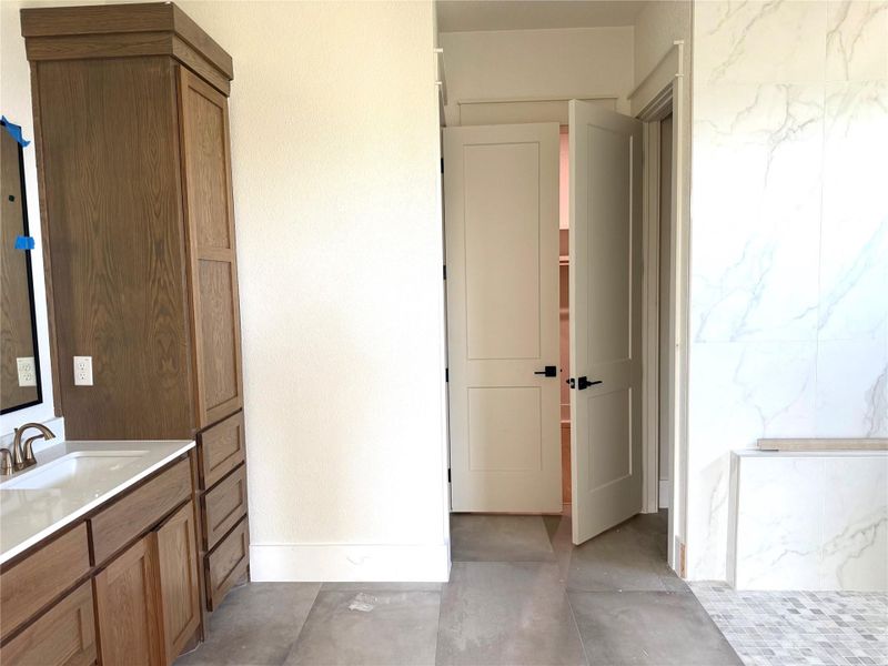 Full bath with vanity and concrete flooring