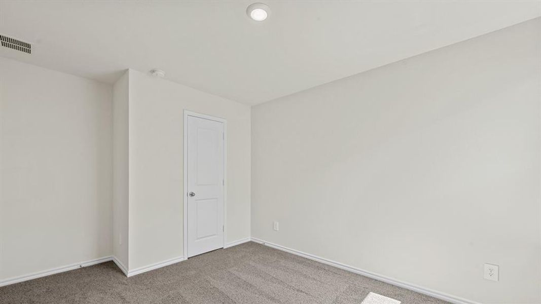 Room featuring neutral wall finishes, gray carpet flooring, a white interior door, and a recessed ceiling light Room featuring neutral wall finishes, gray carpet flooring, a white interior door, and a recessed ceiling light