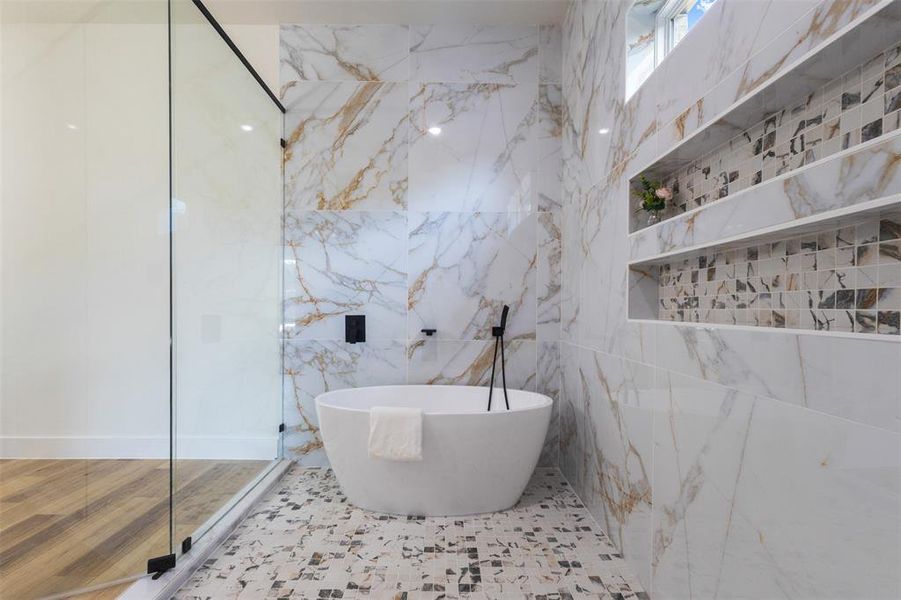 Full bathroom featuring a freestanding tub, walk in shower, and tile walls