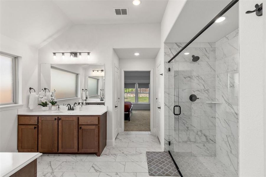 Bathroom with vanity, a marble finish shower, light marble finish flooring, ensuite bath, and recessed lighting