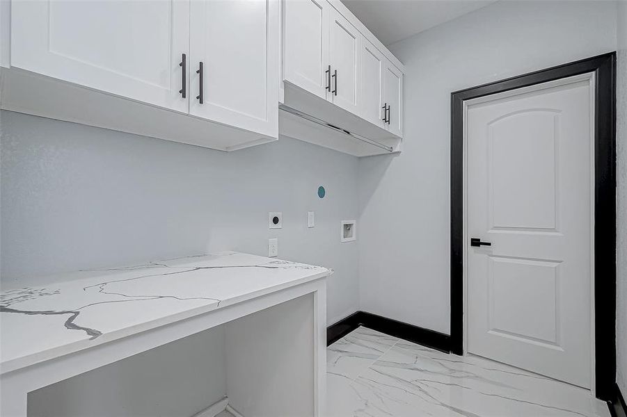 The utility room inside the home is spacious, with storage cabinets and plenty of space.