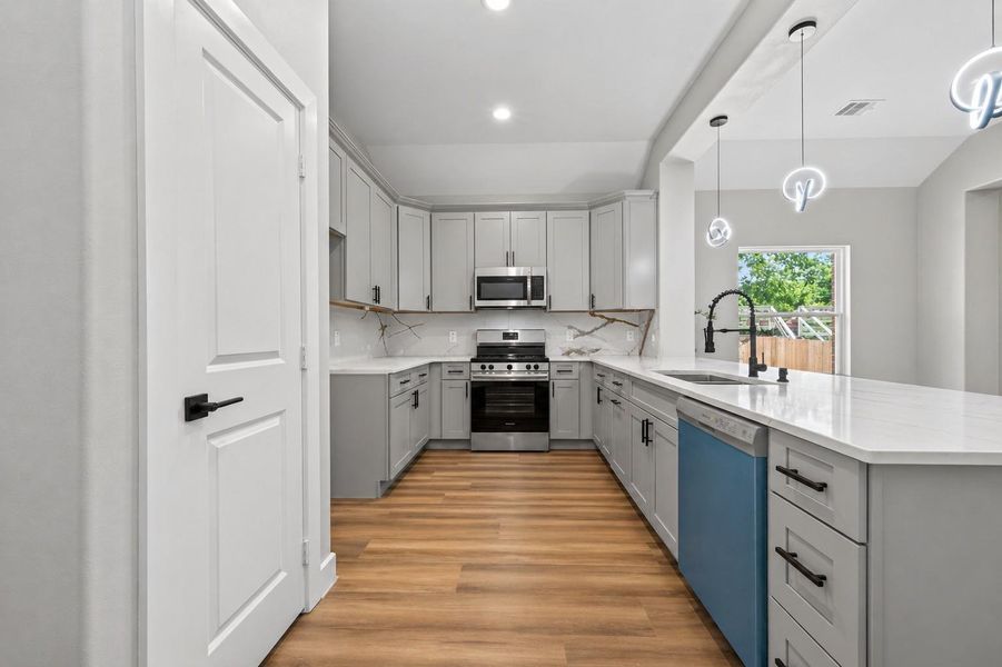 Thoughtfully designed kitchen featuring a large island, ample cabinetry, and an open flow to the main living areas.