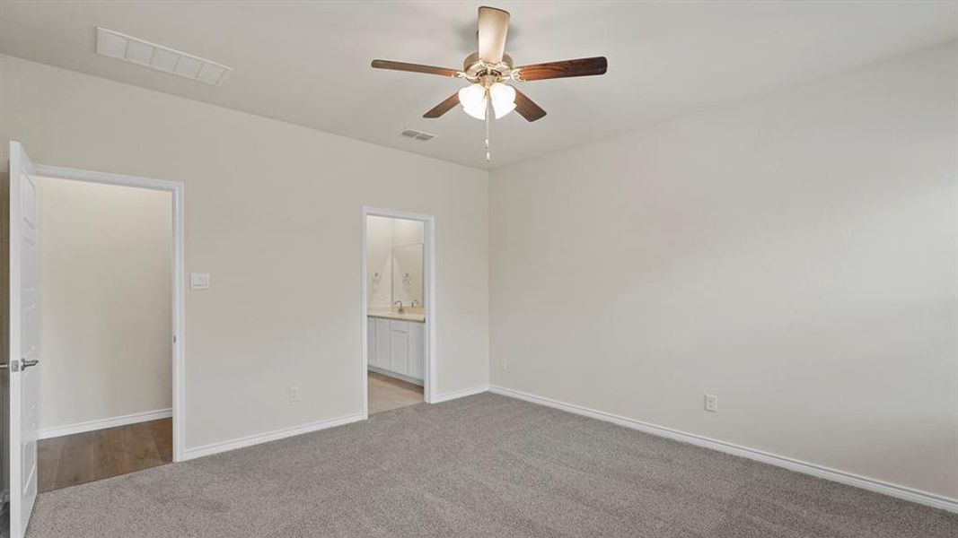 Unfurnished bedroom featuring light carpet, ceiling fan, and ensuite bath Unfurnished bedroom featuring light carpet, ceiling fan, and ensuite bath