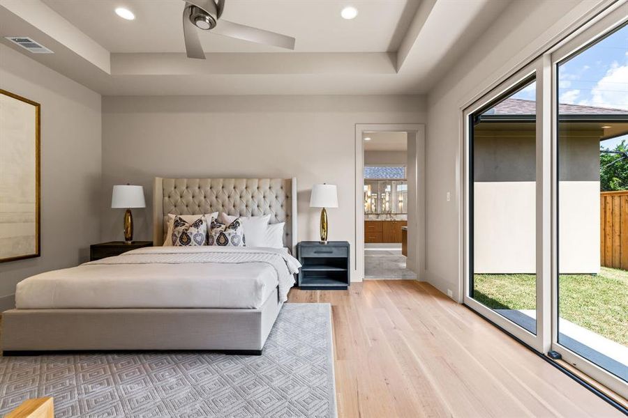 Bedroom featuring multiple windows, access to outside, light wood-style floors, ensuite bath, and recessed lighting Bedroom featuring multiple windows, access to outside, light wood-style floors, ensuite bath, and recessed lighting