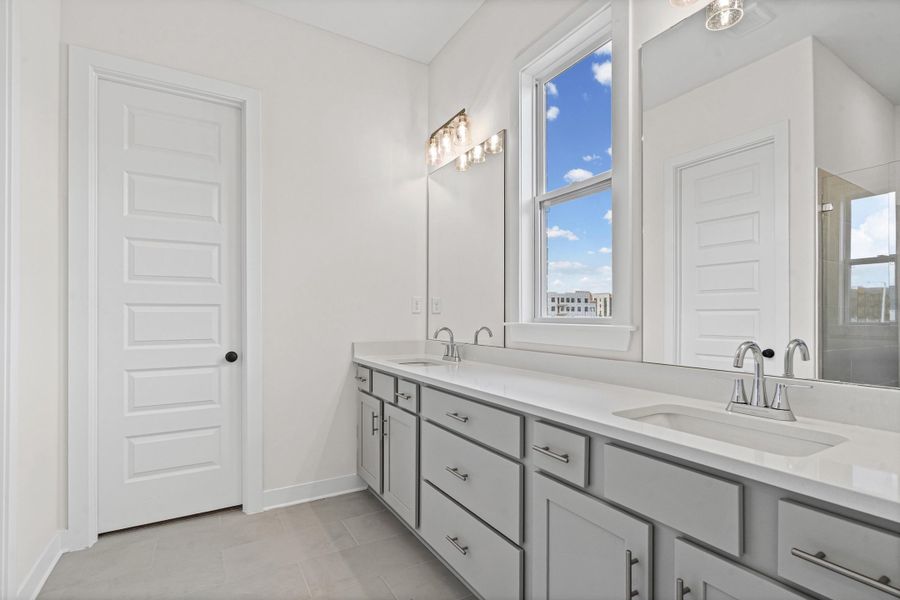 Dual vanity featuring light gray cabinetry, integrated sinks, chrome faucets, and white countertops Dual vanity featuring light gray cabinetry, integrated sinks, chrome faucets, and white countertops