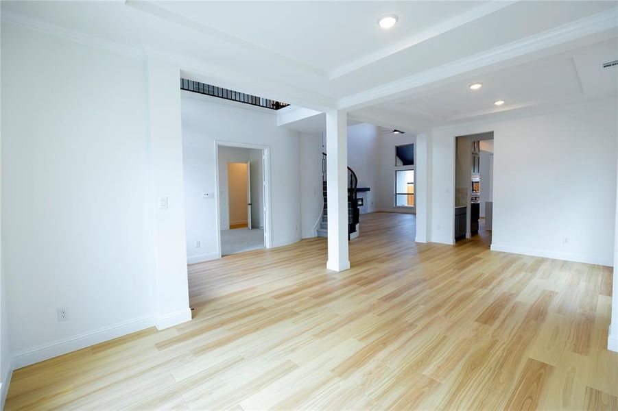 Unfurnished living room with light wood-type flooring, recessed lighting, and stairs Unfurnished living room with light wood-type flooring, recessed lighting, and stairs