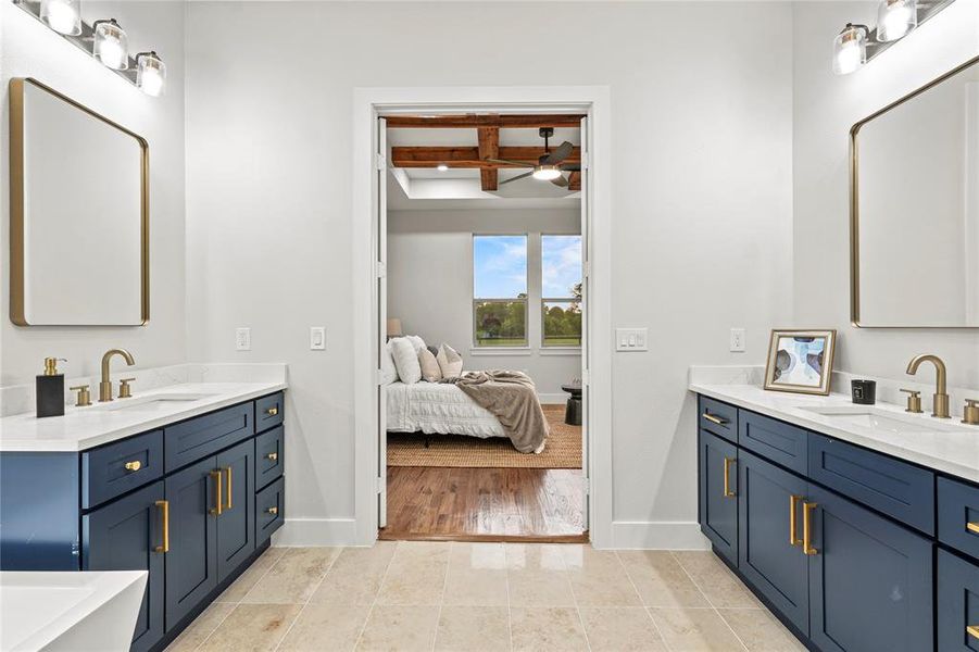 Bathroom with coffered ceiling, two vanities, a ceiling fan, beamed ceiling, and connected bathroom Bathroom with coffered ceiling, two vanities, a ceiling fan, beamed ceiling, and connected bathroom