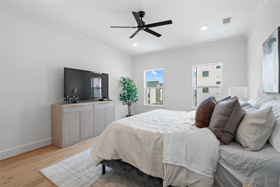 This generous third-floor primary suite showcases a king-sized bed and a stylish media setup, offering a luxurious balance of comfort, function, and modern design. This generous third-floor primary suite showcases a king-sized bed and a stylish media setup, offering a luxurious balance of comfort, function, and modern design.