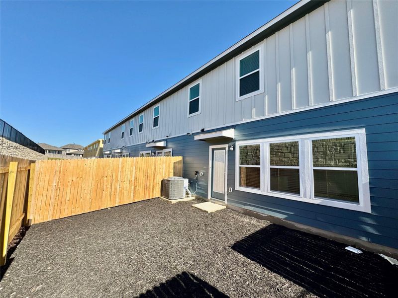 Back of house with board and batten siding and a fenced backyard Back of house with board and batten siding and a fenced backyard