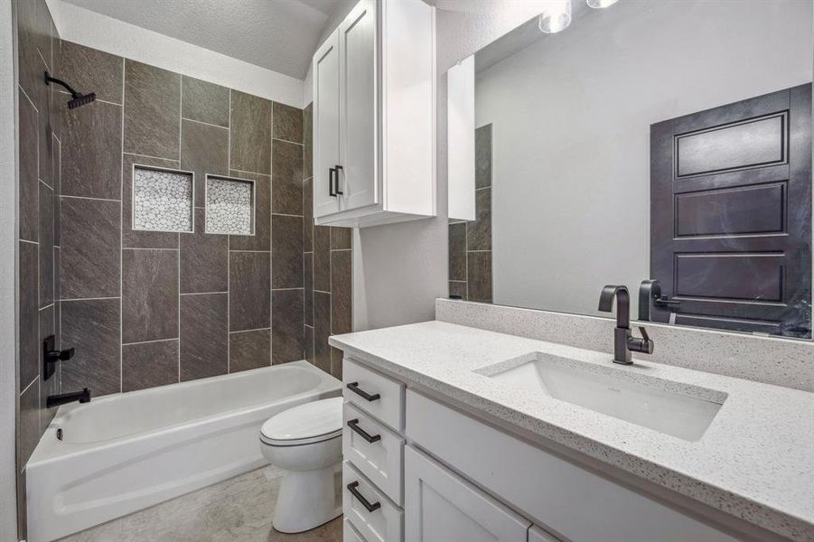 Full bathroom with toilet, tiled shower / bath, and vanity