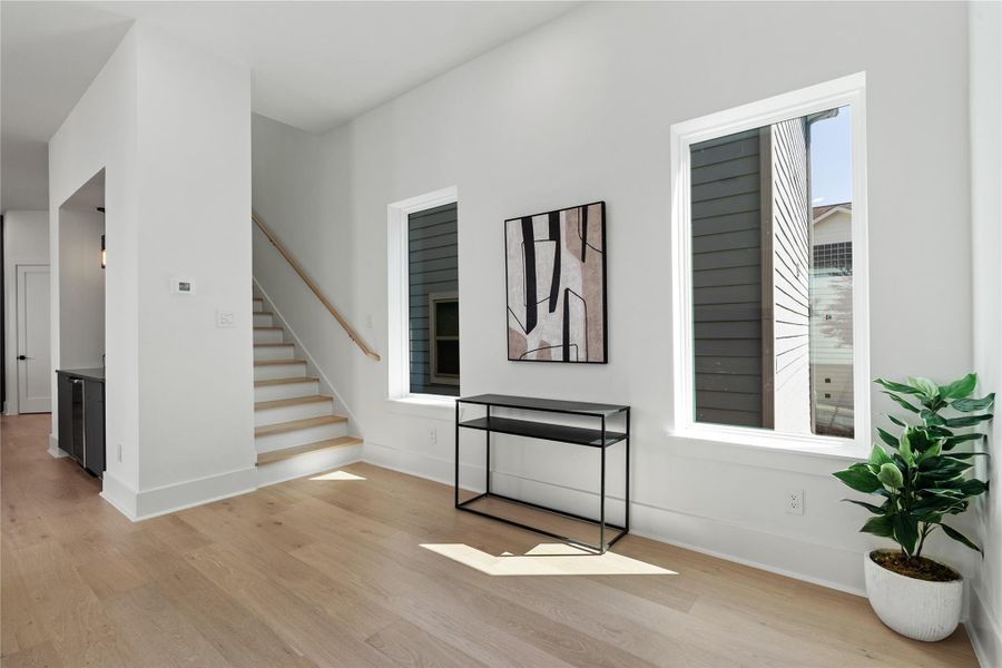 A light-filled gallery moment anchors the second floor, where proportioned Low-E windows wash wide-plank oak floors in sun and frame the clean geometry of the staircase. The adjacent built-in bar tucks neatly into an architectural niche, preserving flow while elevating daily rituals. It’s a serene pause point between living and dining—purposeful, refined, and quietly luxurious. A light-filled gallery moment anchors the second floor, where proportioned Low-E windows wash wide-plank oak floors in sun and frame the clean geometry of the staircase. The adjacent built-in bar tucks neatly into an architectural niche, preserving flow while elevating daily rituals. It’s a serene pause point between living and dining—purposeful, refined, and quietly luxurious.