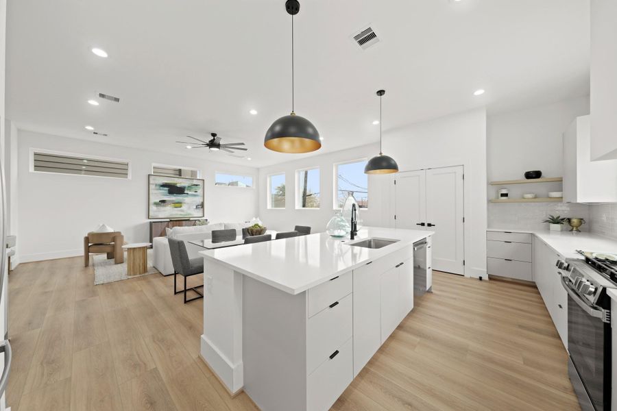 Providing additional counter and meal prep space, the centrally located island comes complete with a stainless steel under-mount sink, pots and pans drawers and a pull-out trash bin. Providing additional counter and meal prep space, the centrally located island comes complete with a stainless steel under-mount sink, pots and pans drawers and a pull-out trash bin.