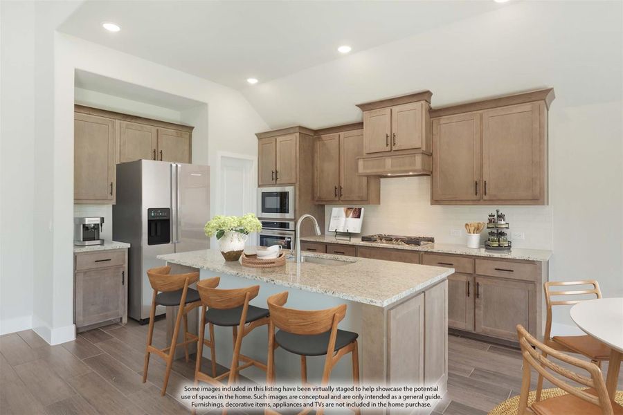 Kitchen with tan wood cabinets, granite island with seating, and stainless steel appliances Kitchen with tan wood cabinets, granite island with seating, and stainless steel appliances