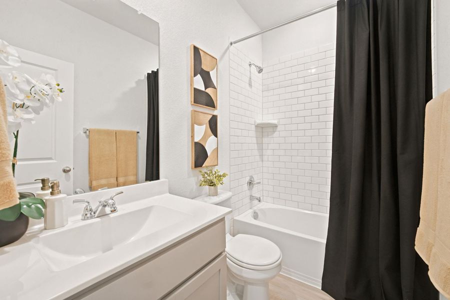 Crisp subway tile surrounds the built-in tub in this bright, clean bathroom space.