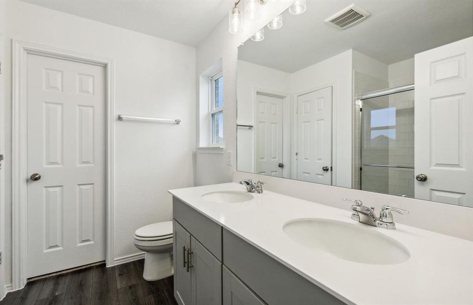 Elegant owner's bathroom with dual vanity and oversized shower*real home pictured