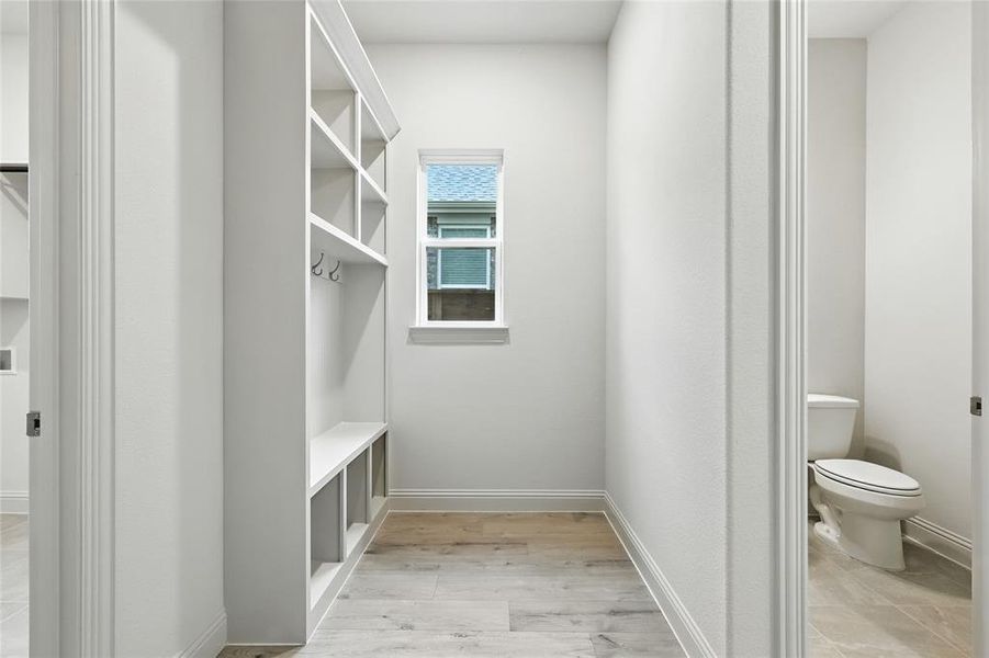 Mudroom with light wood-style flooring and baseboards