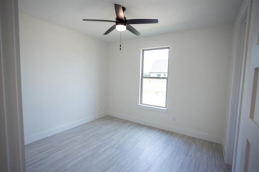 Empty room with light wood-type flooring and ceiling fan Empty room with light wood-type flooring and ceiling fan