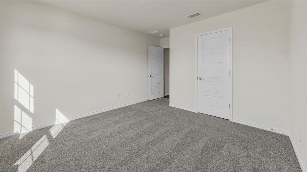 Neutral-toned room featuring light gray carpeting and white walls