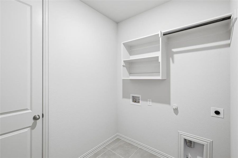 Laundry room with gas dryer hookup, hookup for a washing machine, light tile patterned floors, and hookup for an electric dryer Laundry room with gas dryer hookup, hookup for a washing machine, light tile patterned floors, and hookup for an electric dryer