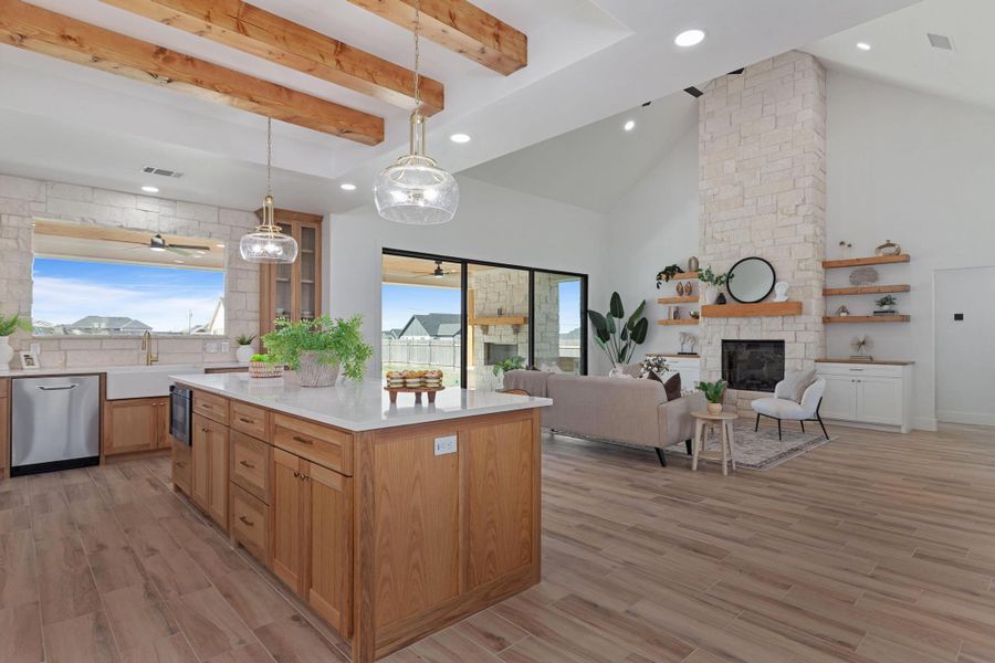 Kitchen with a fireplace, open floor plan, a center island, light wood-style floors, and hanging light fixtures Kitchen with a fireplace, open floor plan, a center island, light wood-style floors, and hanging light fixtures