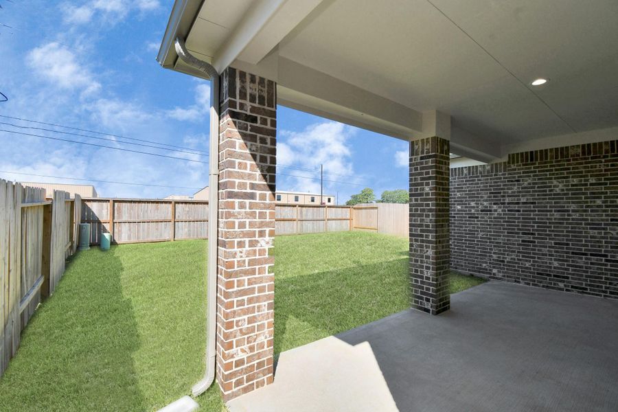 Experience outdoor living at its finest on this expansive covered patio, thoughtfully designed for BBQs and delightful outdoor dining. Sample photo of completed home with similar floor plan. Actual colors and selections may vary.