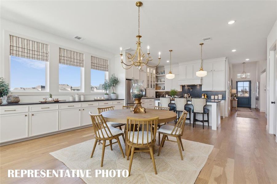 The spacious light filled dining room offers a row of cabinets creating the ideal serving space when hosting lively dinner parties or family get togethers.  REPRESENTATIVE PHOTO