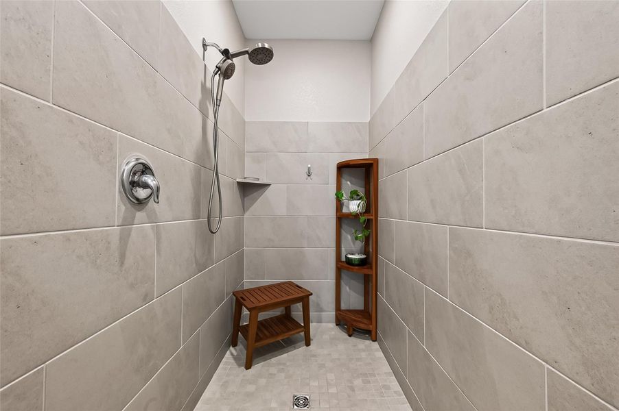 Primary bath featuring a spacious walk-in shower with tiled surround. Primary bath featuring a spacious walk-in shower with tiled surround.