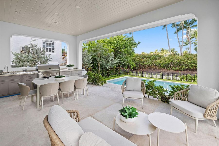 Outside living room with kitchen overlooks pool Outside living room with kitchen overlooks pool