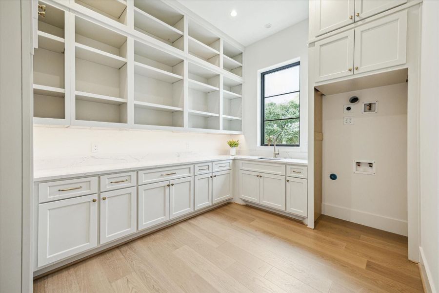Right off of the kitchen is this combined prep area and pantry with extended quartz counter, sink and room for a second fridge and first floor washer/dryer which can be fitted for secondary range and hood.