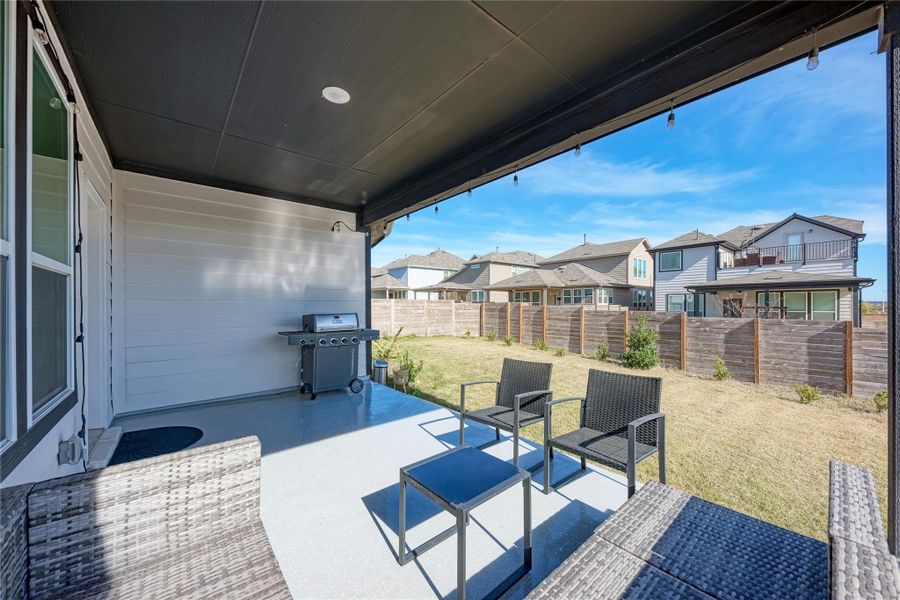 Covered patio featuring a painted concrete surface and string lighting