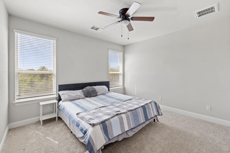 Bedroom with carpet floors and a ceiling fan Bedroom with carpet floors and a ceiling fan
