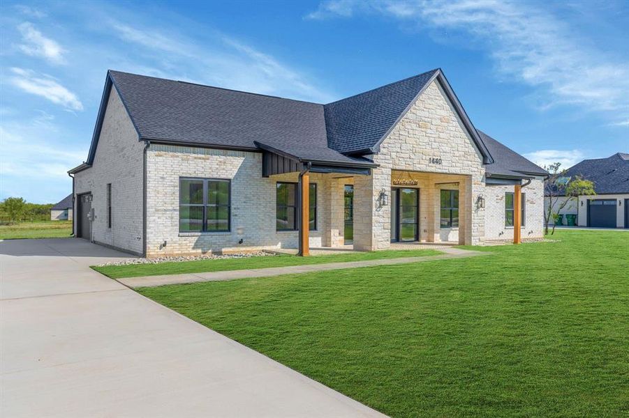 Front view of house featuring brick and stone facade with porch.