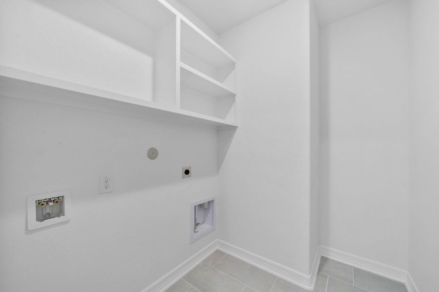 Functional utility room with shelving and convenient laundry hookups