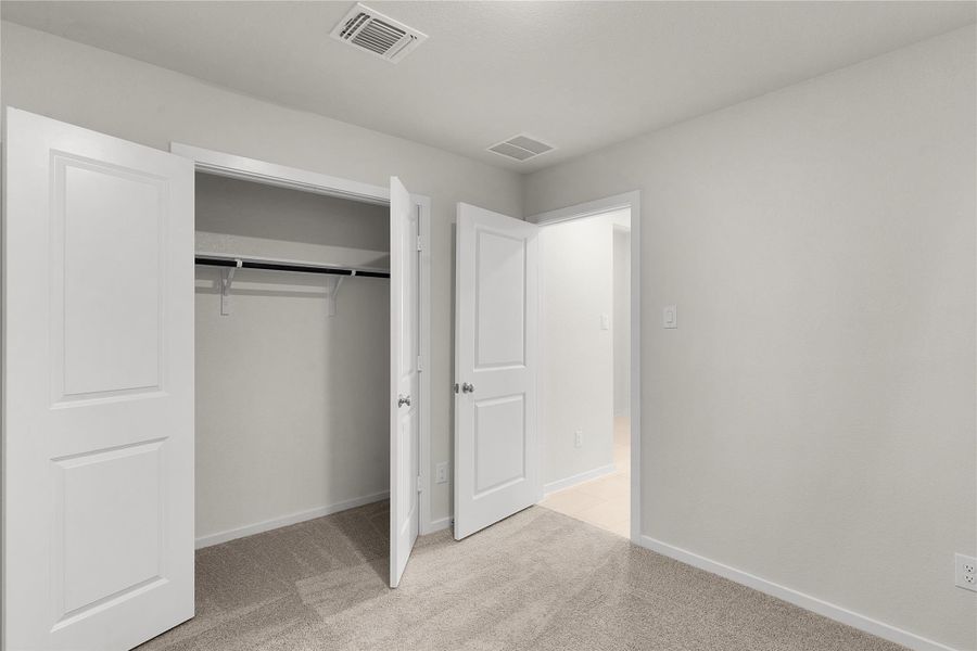 Unfurnished bedroom featuring light carpet and a closet