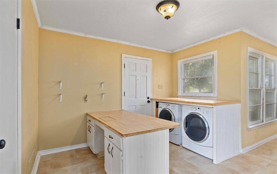 Laundry area featuring separate washer and dryer and crown molding