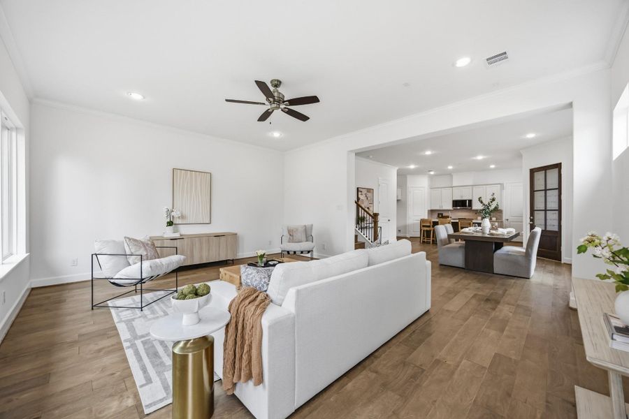 Effortless Flow: The spacious living room, with standard wood flooring, seamlessly connects to the dining area, creating a welcoming space designed for comfort and entertaining.