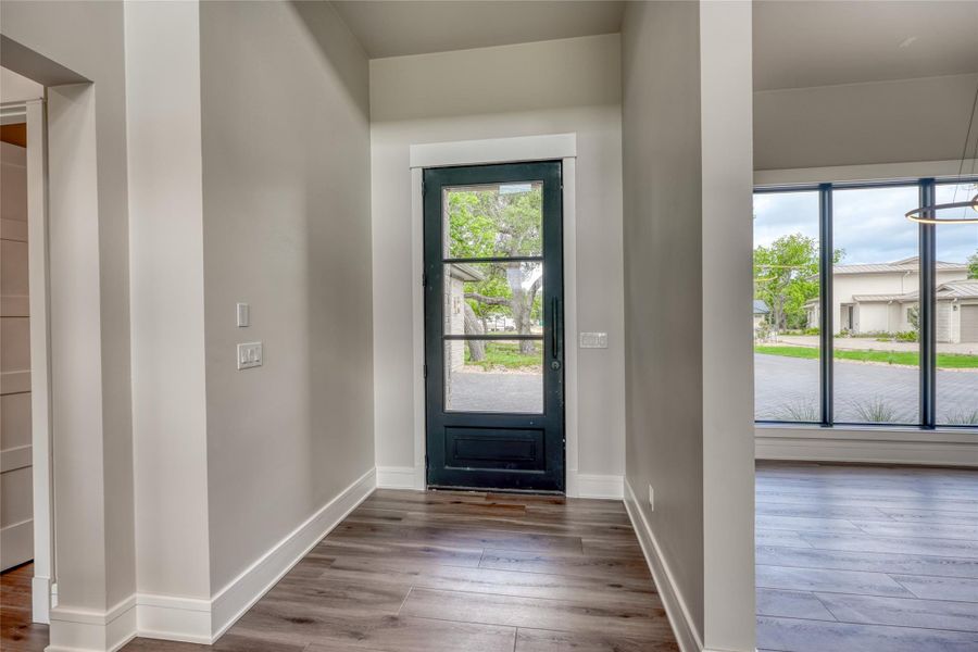 Foyer entrance with dark wood-style flooring and baseboards